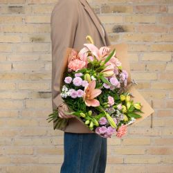 Send en smuk pastel blomsterbuket, der holder længere med liljer og nelliker