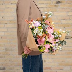 Pastel markbuket med lyserøde liljer, kamilleblomster og små hvide blomster. Bestil den smukke pastelbuket på flowr.dk